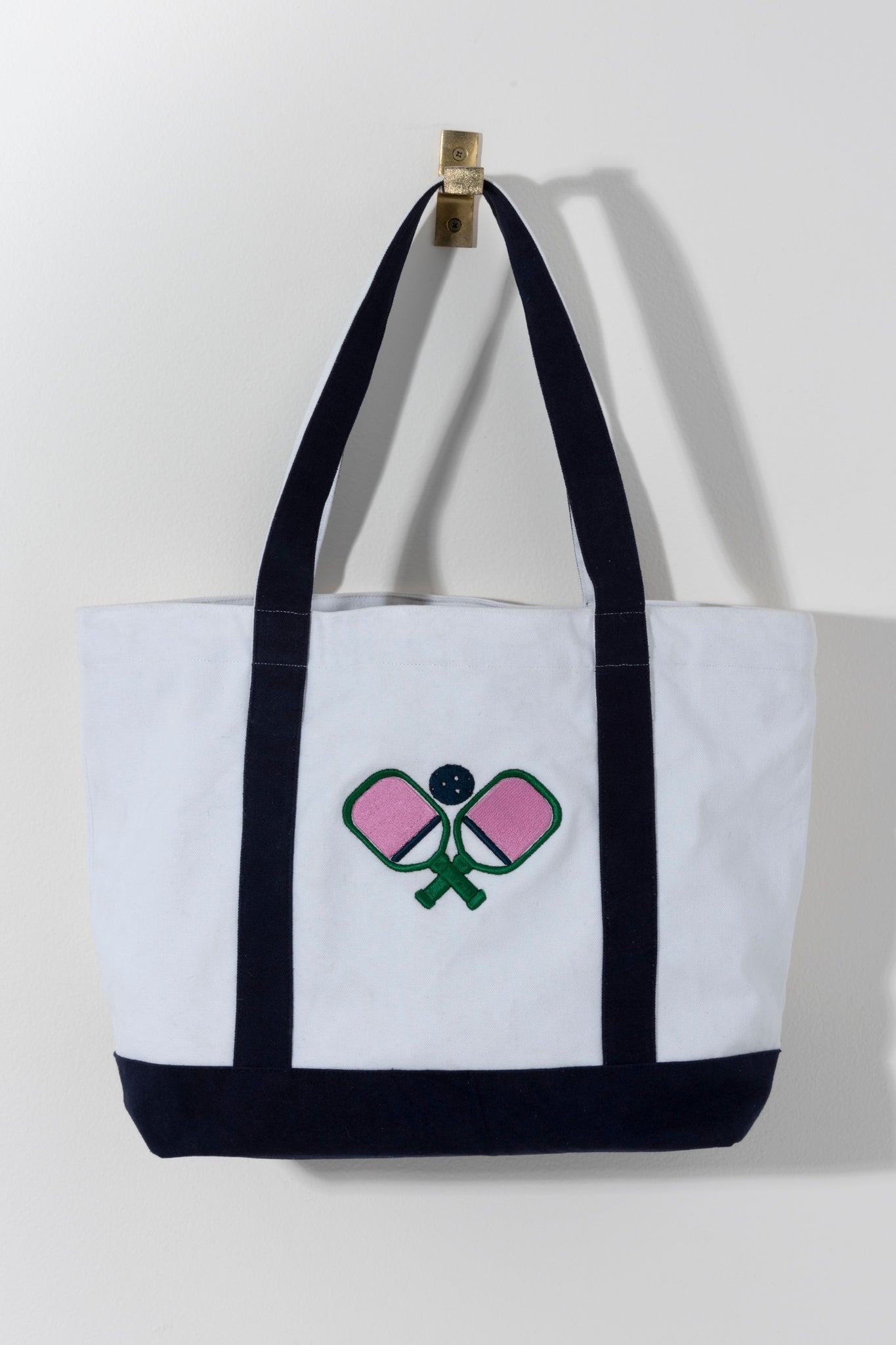 Stand out on the court with Shiraleah's Pickleball Paddles Tote. Made from durable cotton canvas with a subtle embroidered design, you'll never leave an essential behind again. Whether you're a star player or just picking up on the trend, this is the perfect bag for the pickleballer in your life. Pair with other items from Shiraleah's Pickleball collection to complete your look!