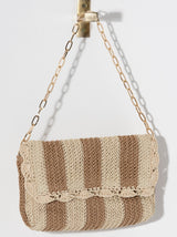 Add some summertime charm to your look with Shiraleah's Sandy Shoulder Bag. Made from woven paper straw with a single gold chain handle, this bag is the perfect transitional piece to wear in the sunshine or out at night. The classic stripe design matches any outfit effortlessly. Pair with other items from Shiraleah to complete your look!
