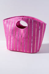 Add a pop of color to your beach trip with Shiraleah's Zoe Tote. Made from woven paper straw in a bright fuchsia color and featuring a subtle metallic stitching accent, this vibrant bag is the perfect summer accessory. The large size and sturdy cutout top-handles make its design as practical as it is stylish. Pair with the matching Zoe Zip Pouch and other items from Shiraleah to complete your look!