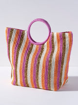Bring some brightness with you to the beach this summer in Shiraleah's Delilah Tote. Made from woven paper straw with chic circular handles, this tote is the perfect accessory for any warm weather activity. Its pink handles match the stripes of pink, gold, orange, and natural straw colors creating an elegant color scheme to match your favorite outfit. Pair with the Delilah Zip Pouch and other items from Shiraleah to complete your look! 
