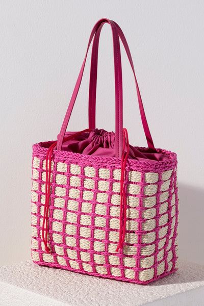 Accessorize with color this summer by carrying Shiraleah's Juanita Tote. Made from woven paper straw with a chic pink cotton lining, this trendy bag will fit your favorite outfit perfectly. The drawstring closure ensures all your items are safely enclosed, while creating a unique silhouette that is sure to stand out from the crowd. Pair with other items from Shiraleah to complete your look!