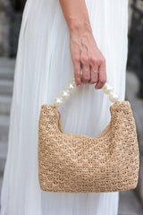 Stand out from the crowd with Shiraleah's Sonata Bag. This classic purse features a unique top handle composed entirely of faux pearls, complimenting the natural tan color of the woven fabric. Whether you're a bride or just a lover of pearls, this bag is sure to turn heads this summer. Pair with other items from Shiraleah's Hitched collection to complete your look!
