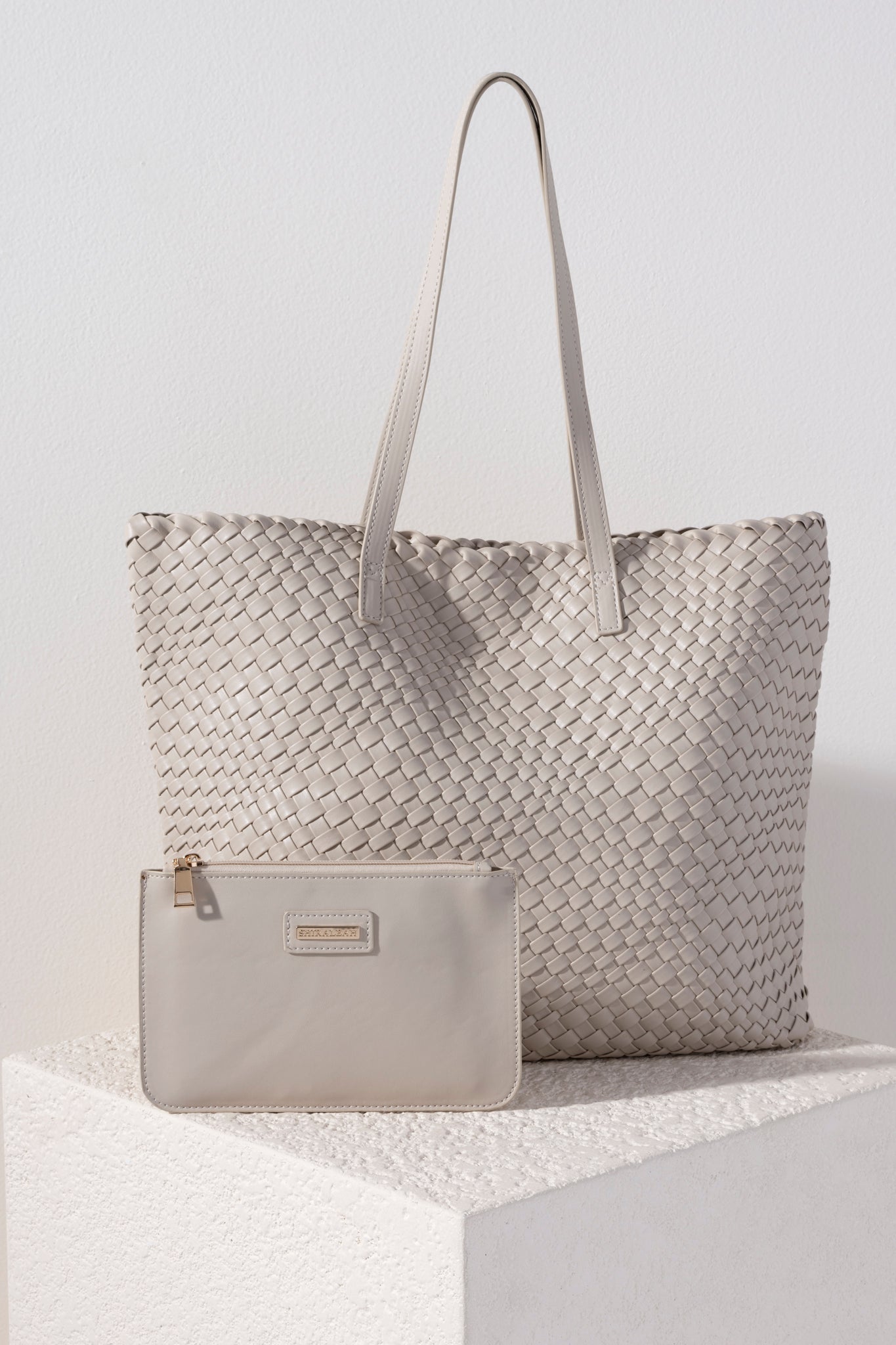 Give your handbag collection a sleek update with Shiraleah's Blythe Tote. This sophisticated bag is made from woven vegan leather and is the perfect size to carry all of your essentials. It even comes with a matching, removeable top zip pouch to secure your smallest belongings. Pair with other items in Shiraleah's Blythe collection to complete your look!