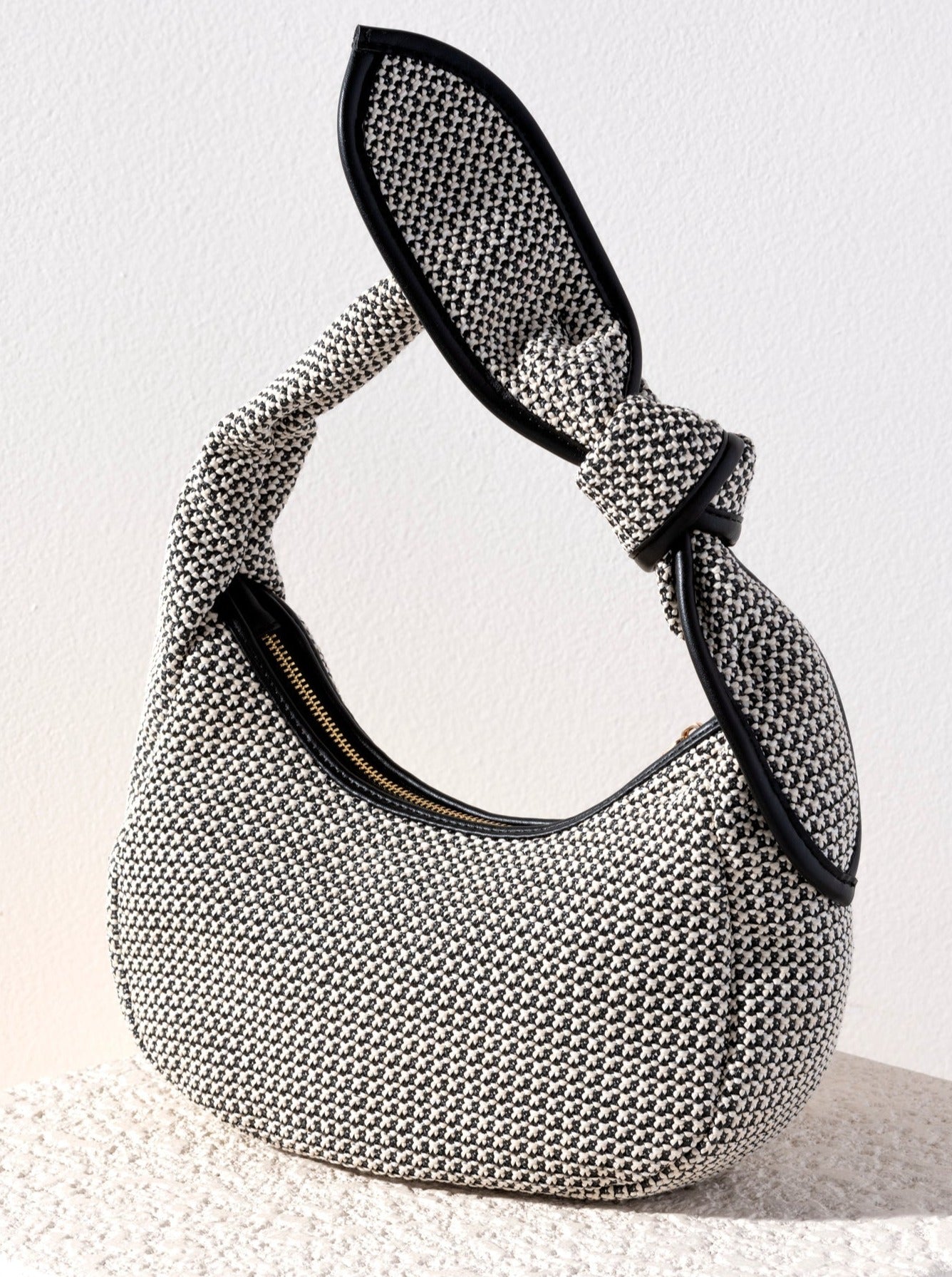 Turn heads on the beach this summer with Shiraleah's Sonya Mini Hobo. Made with an elegant woven design featuring PU accents and a delicate knot detail, this bag has every trend you could hope for all in one. Pair with other items from Shiraleah to complete your look!
