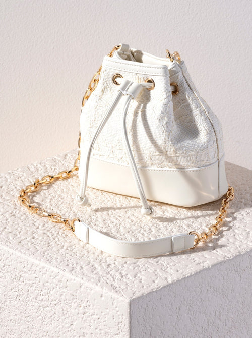 Spruce up your summer wardrobe with Shiraleah's trendy Adrienne Bucket Bag. Made from trendy raffia fabric, the bag's unique silhouette cinches at the top with a drawstring closure. Its cross-body chain makes this bag the perfect addition to any summer outfit. Pair with other items from Shiraleah to complete your look!
