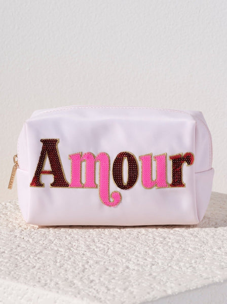 Carry all your odds and ends in style with Shiraleah's Cara "Amour" Zip Pouch. Made of durable polyester in a light blush color, this rectangular case is the perfect size to carry your makeup or toiletries on the go. The trendy multicolored sequin embroidery spells the word "Amour", adding a little love wherever you take it. Pair with other items from Shiraleah to complete your look!
